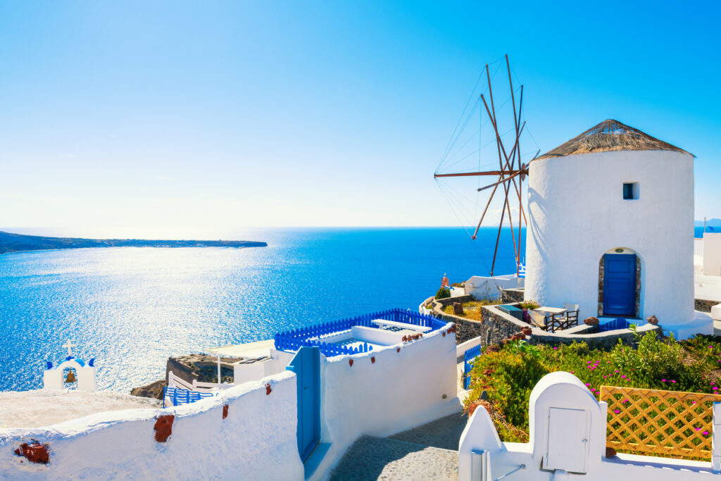 White architecture in Santorini island, Greece. Windmill in Oia town at sunny day. Travel and vacation concept